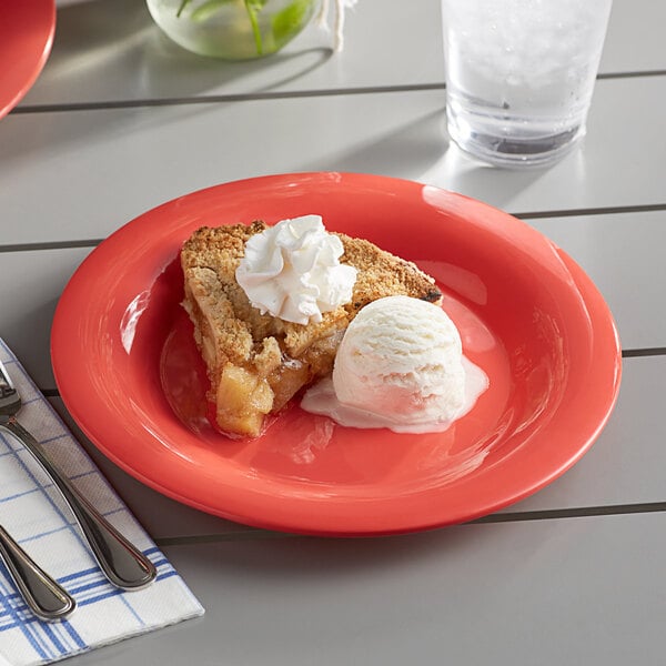 An Acopa Foundations orange melamine plate with a slice of apple pie and ice cream on it.