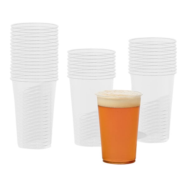 A stack of Tossware Natural plastic cups with a glass of beer