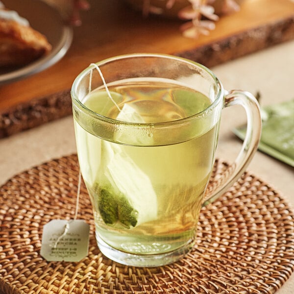 A glass mug of Harney & Sons Japanese Sencha Tea with a tea bag in it.