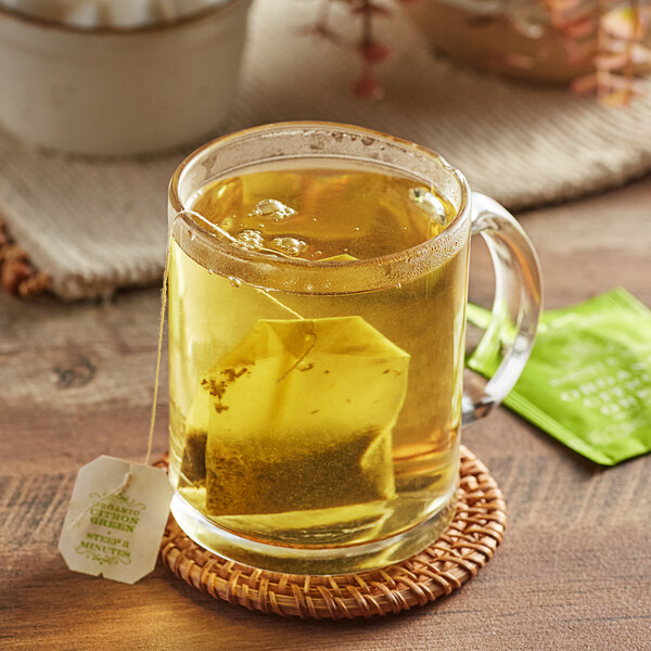 A glass mug of Harney & Sons Organic Citron Green tea with a tea bag inside.