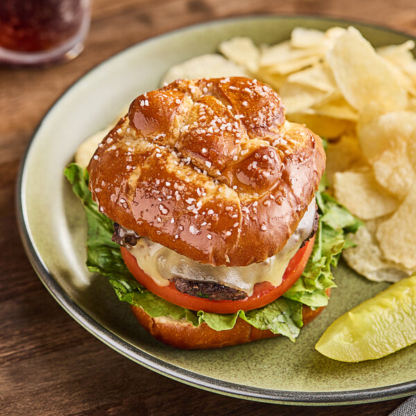 A burger on a plate with lettuce and tomato.