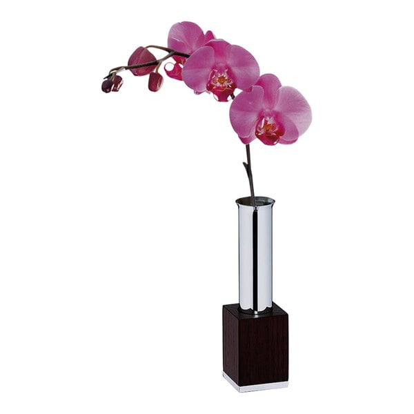 A stainless steel and dark wood WMF vase with a purple orchid.