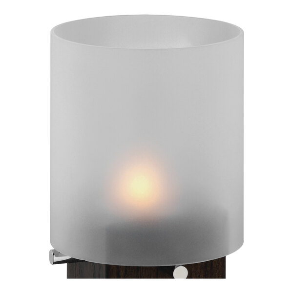 A white WMF Pure Exclusiv glass shade with a lit candle inside.