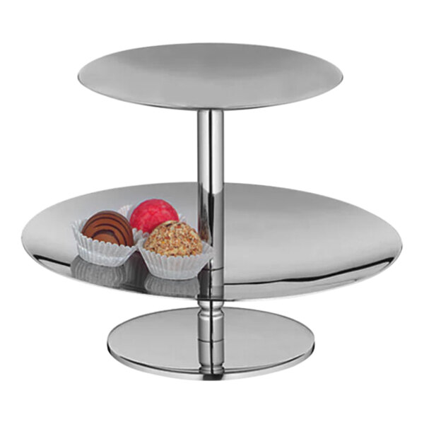 A two-tier stainless steel pastry stand holding chocolates and cookies.