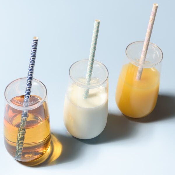 Three Tossware glasses with straws and drinks in them.