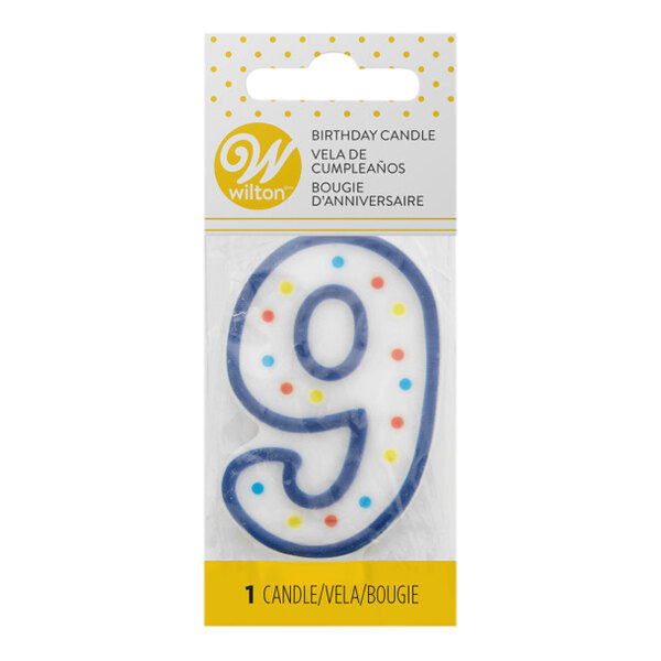 A white Wilton birthday candle with blue polka dots and a number nine on it.