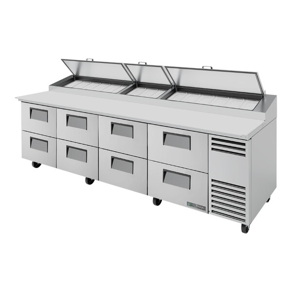 A True refrigerated pizza prep table with eight drawers.