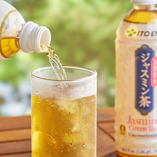 A bottle of Ito En Jasmine Green Iced Tea pouring into a glass of ice.