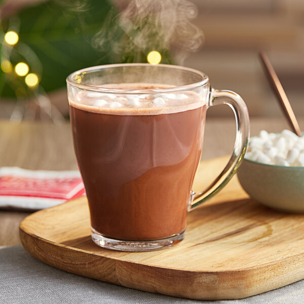 A glass of Nestle hot chocolate with marshmallows on a wooden tray.