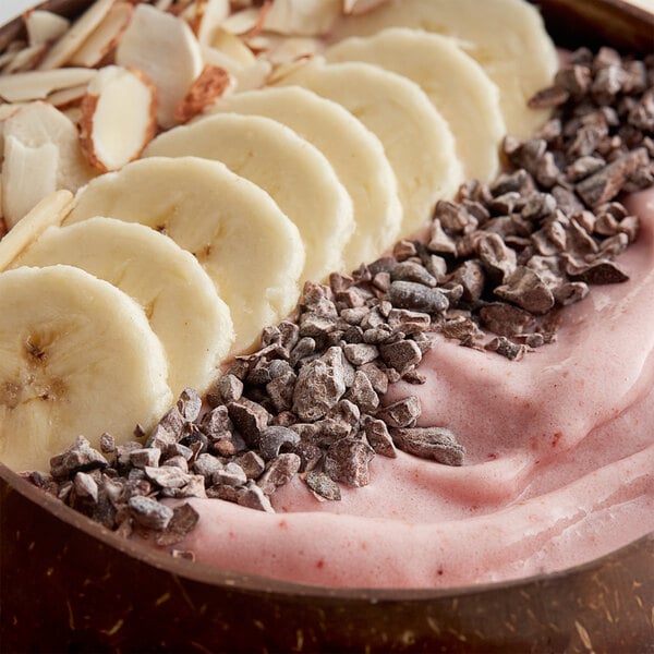 A bowl of chocolate banana smoothie with banana slices and TCHO Crush Cacao Nibs.