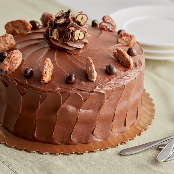 A chocolate cake with TCHO 68% Dark Chocolate hexagons and nuts on top.