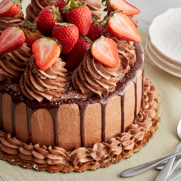 A chocolate cake with strawberries on top displayed on a table.
