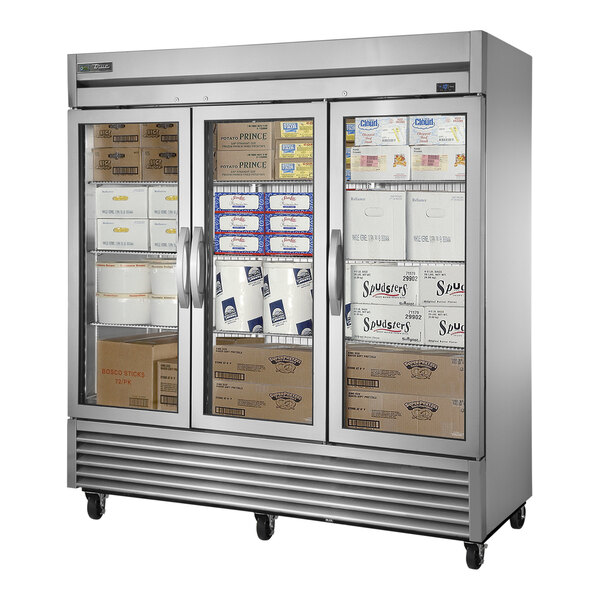 A True stainless steel reach-in freezer with glass doors.