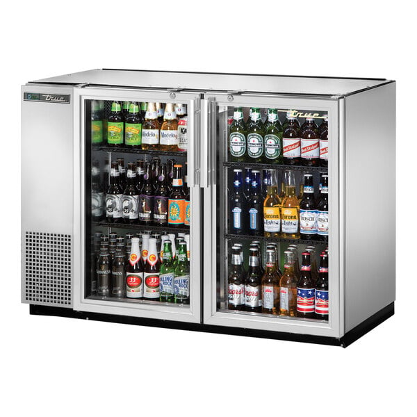 A True stainless steel narrow back bar refrigerator with bottles of beer inside.