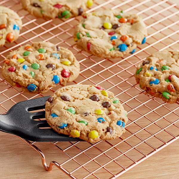 A cookie with M&M's Mini Peanut Butter Milk Chocolate Candies on a metal rack.