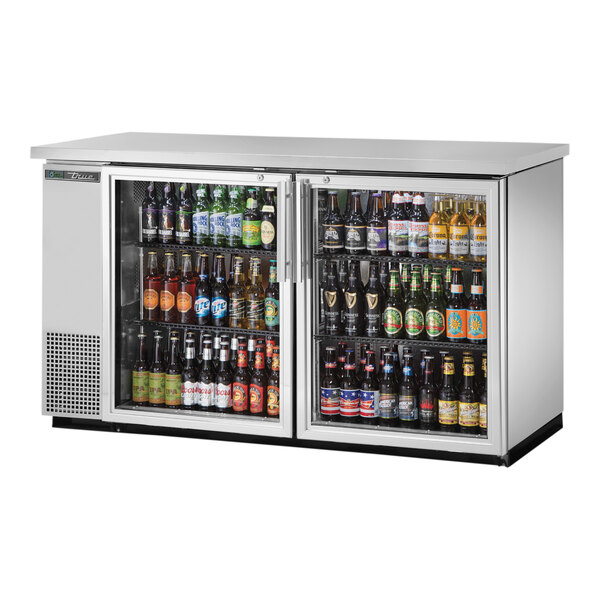 A True stainless steel back bar refrigerator with swing glass doors filled with bottles of beer.