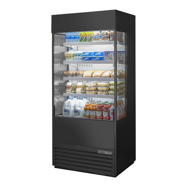 A black True refrigerated air curtain merchandiser with food on shelves.