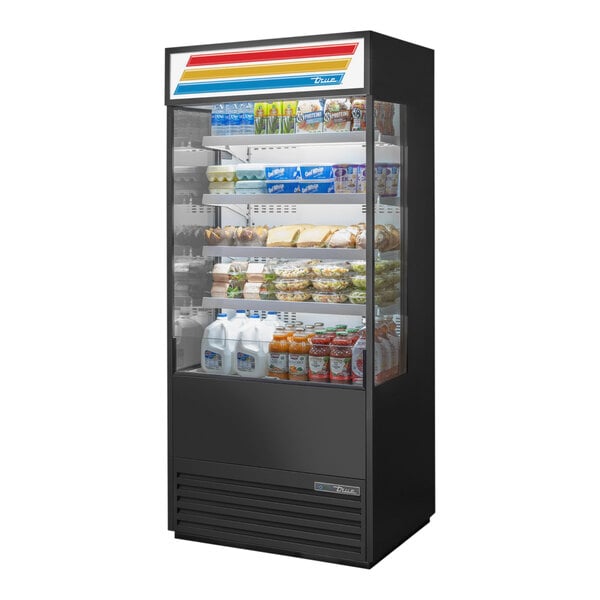 A True refrigerated air curtain merchandiser with food on shelves.