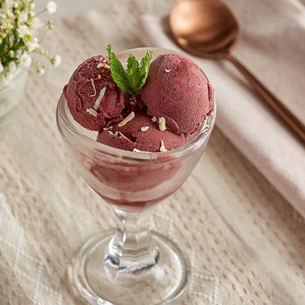 A glass of Sambazon Organic Acai Select Blend Sorbet with a spoon in it.