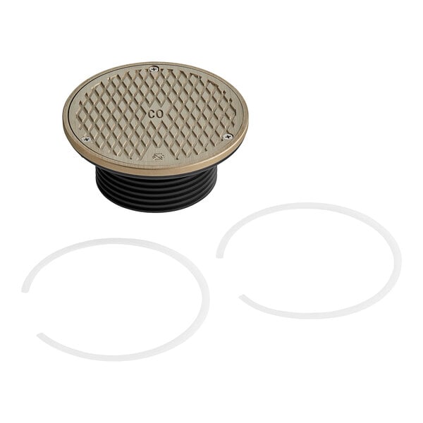 A metal round floor drain cover with black plastic rings.