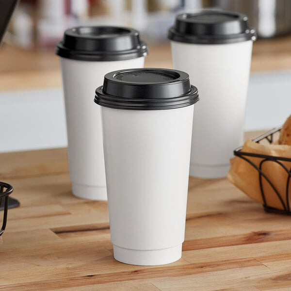 A group of Choice white paper cups with lids.