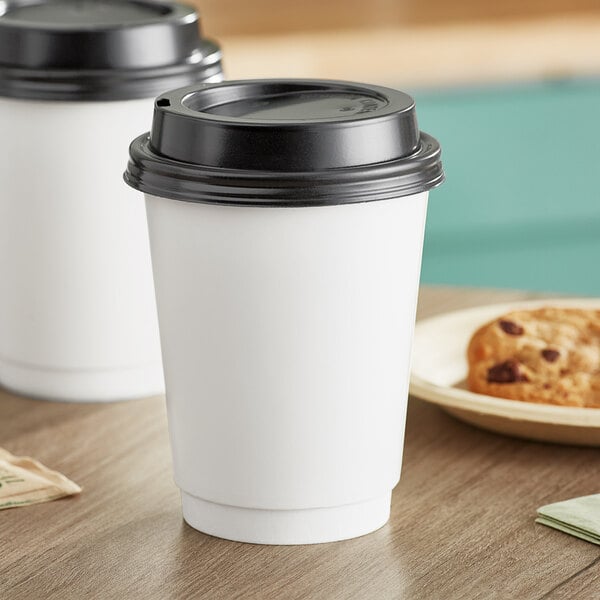 Two white Choice paper cups with black lids on a table.