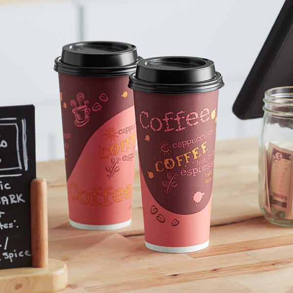 Two Choice coffee cups on a table with a chalkboard sign.