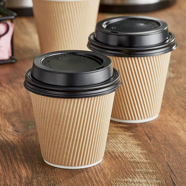A couple of brown and black Choice paper hot cups with black lids.