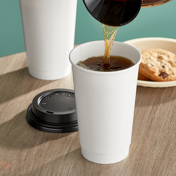 A person pouring coffee into a white Choice double wall paper hot cup.