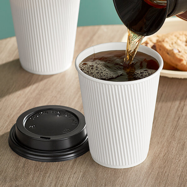 A person pouring coffee into a white Choice paper hot cup.