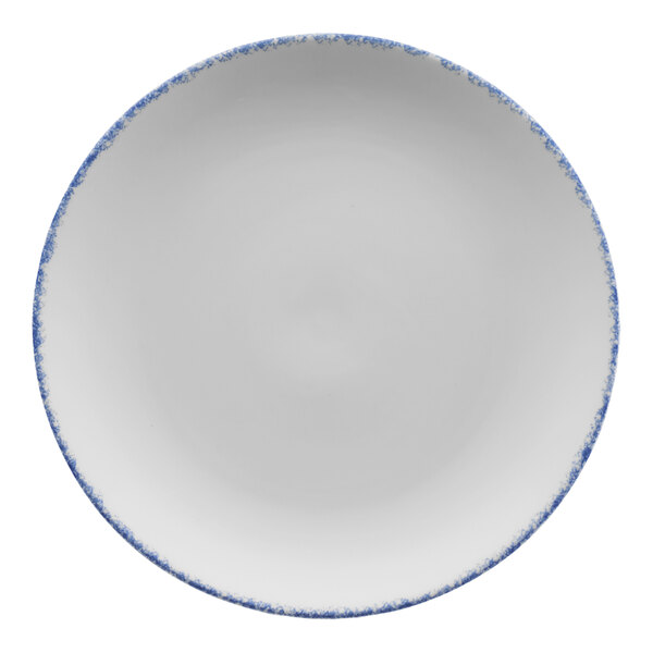 A white porcelain coupe plate with blue speckles and a blue rim.