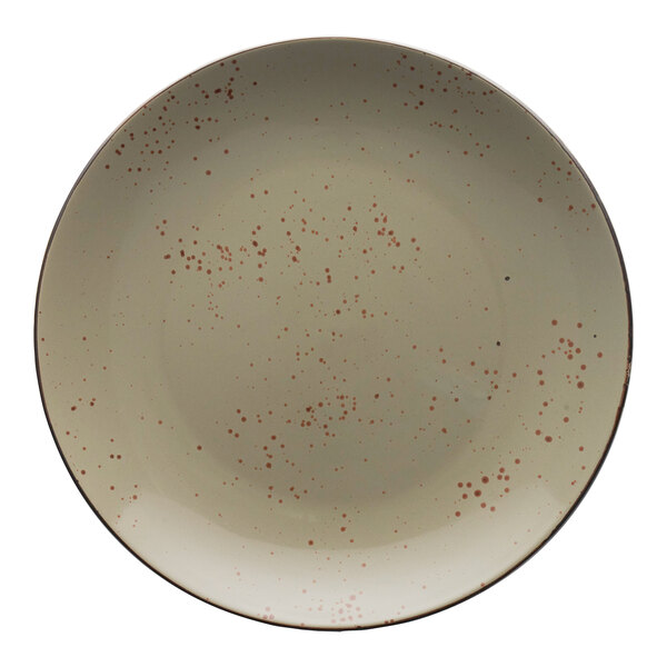 A white stoneware coupe plate with green and brown specks on it.