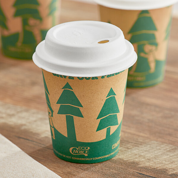 Two EcoChoice Kraft paper cups with tree prints on them sit on a table with a white sugarcane lid.