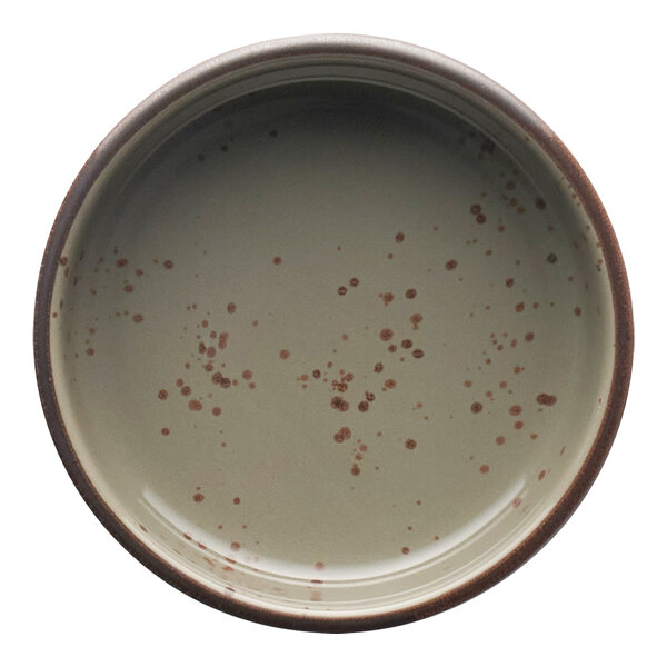 A green and brown speckled stoneware sauce dish.