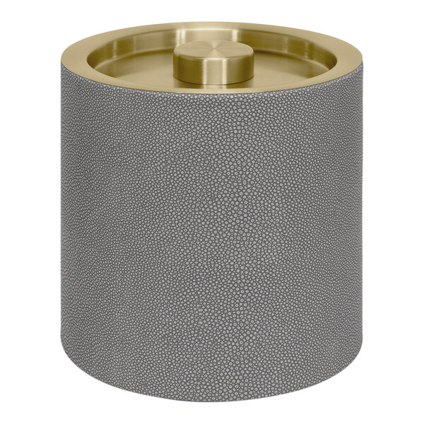 A grey metal cylindrical container with a matte brass lid.