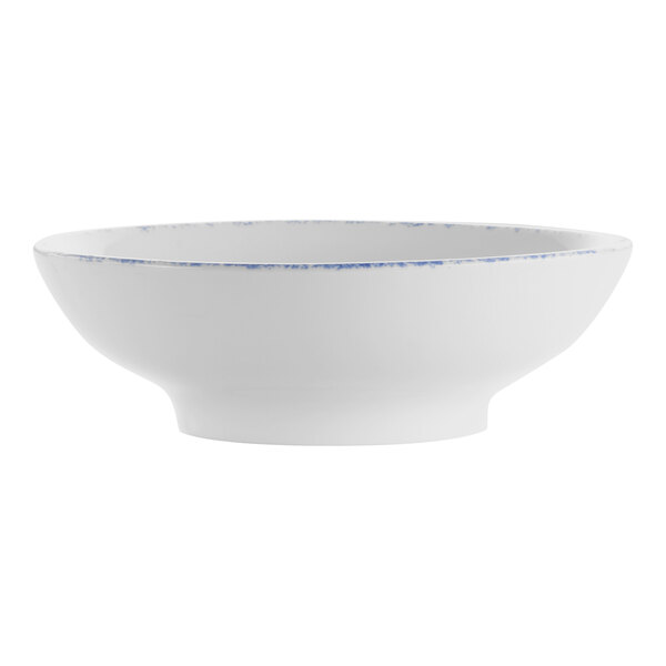 A close-up of a white International Tableware porcelain bowl with blue sponged trim.