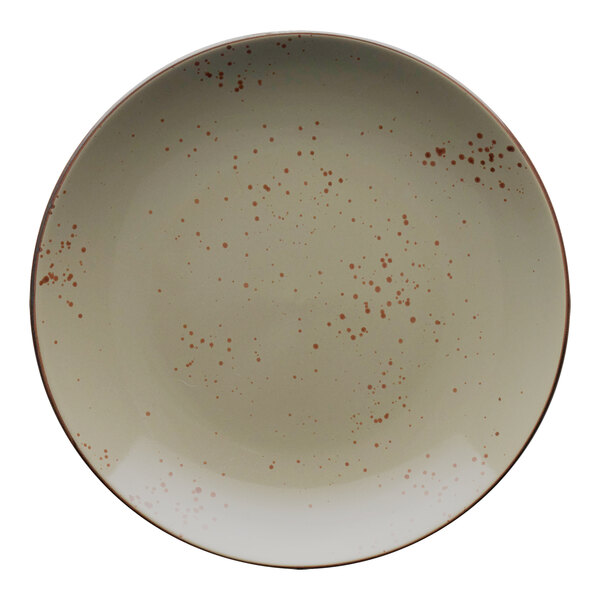 A white stoneware coupe plate with green and brown speckles on it.