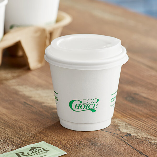 A white EcoChoice double wall paper hot cup with a lid on a table.