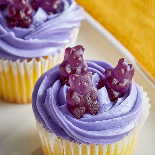 A cupcake with purple frosting and Albanese grape gummi bears on top.