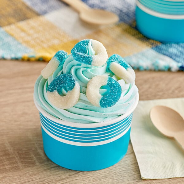 A blue and white frosted cupcake with Albanese Blue Raspberry Gummi Rings on top.