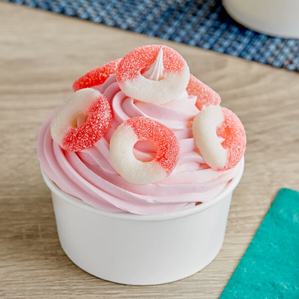 A cup of ice cream with Albanese Watermelon Gummi Rings on top.