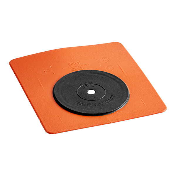 An orange square Oatey wall flashing with a black disc on it.