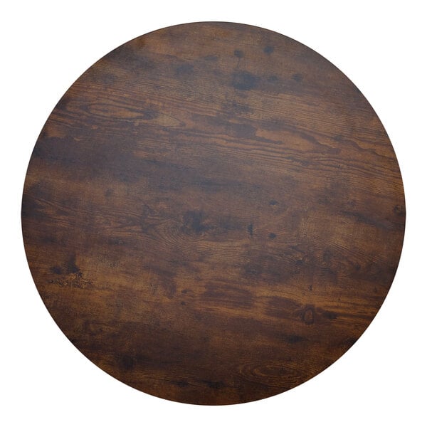 A BFM Seating round wood table top with a dark brown finish.