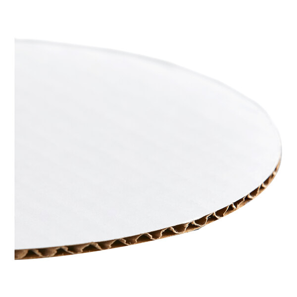 A round, white, corrugated grease-resistant cake circle.