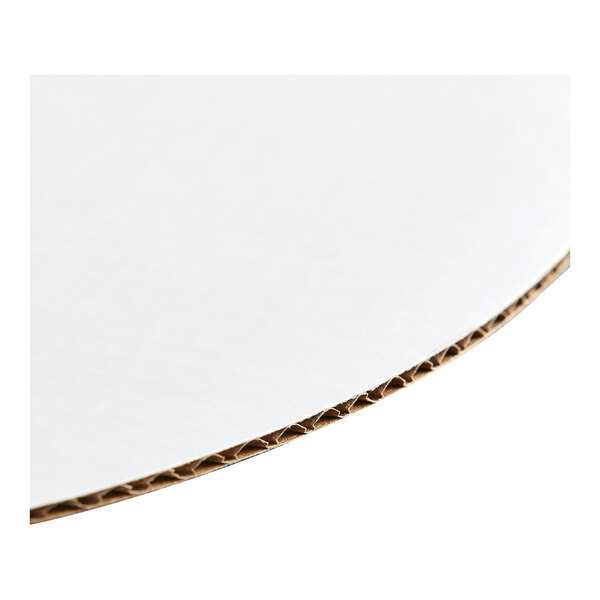 A round, white corrugated cardboard cake circle.
