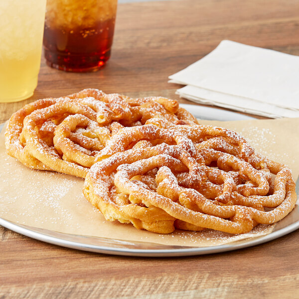 Two J & J Snack Foods funnel cakes on a plate with a drink.
