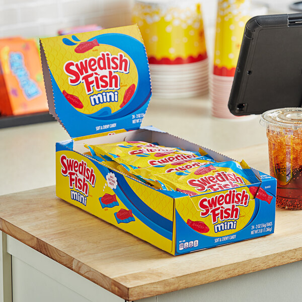 A case of Swedish Fish Mini Soft and Chewy Candy pouches on a table.