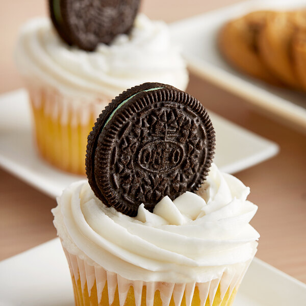 A cupcake with a Nabisco Oreo Mint Cookie on top.
