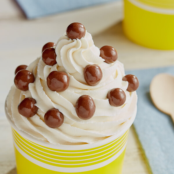 A cup of ice cream with Albanese Milk Chocolate Covered Cookie Dough Bites on top.