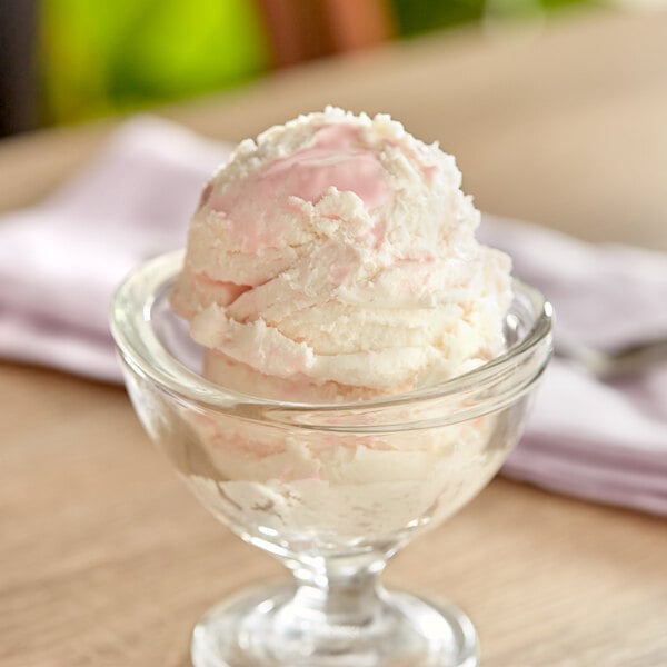 A glass dish with a scoop of I. Rice cotton candy variegate ice cream.